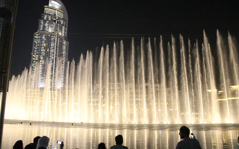 The Address Downtown tower lit at night behind the Dubai Fountain show