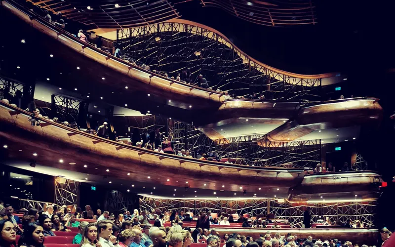 Dubai Opera auditorium: curved timber balconies and seating (landscape crop of portrait original)